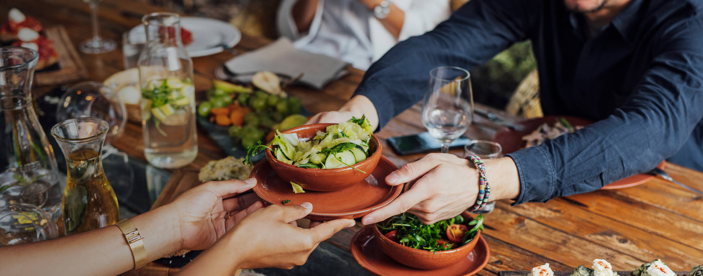Bowl of fresh food being passed across the table