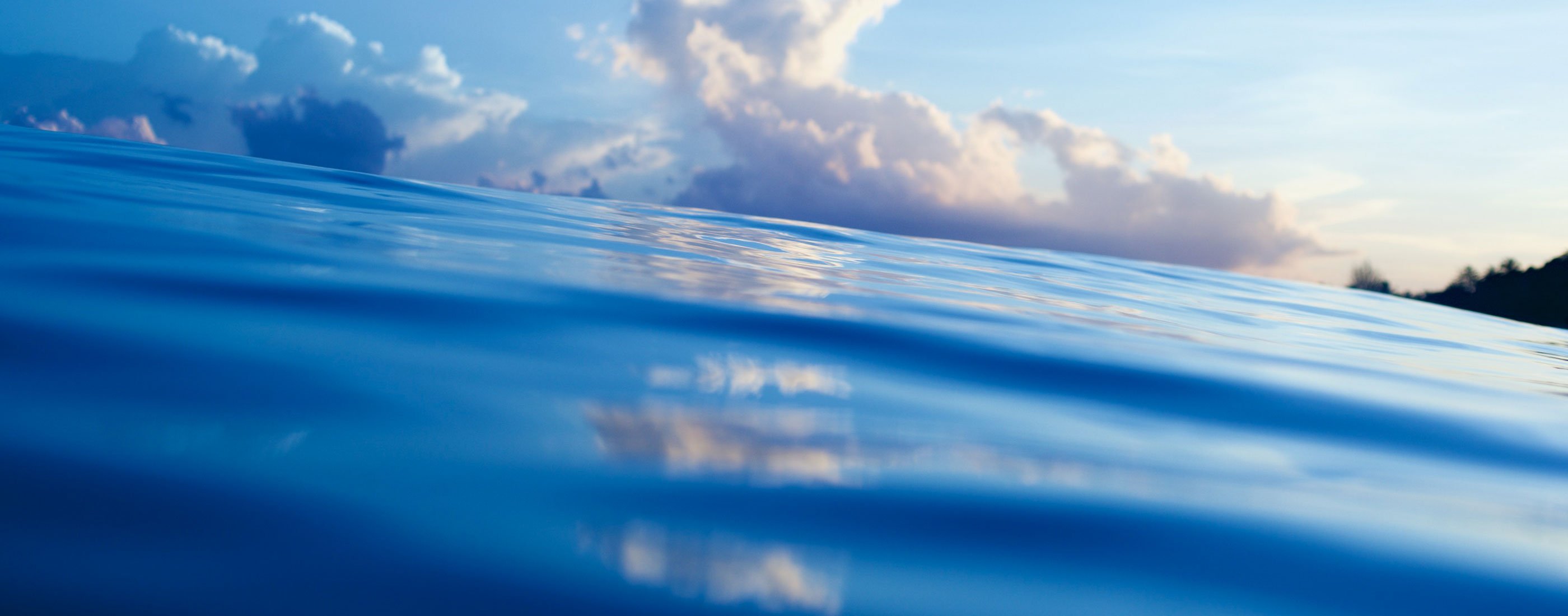 Ocean surface with clouds along the horizon in the background